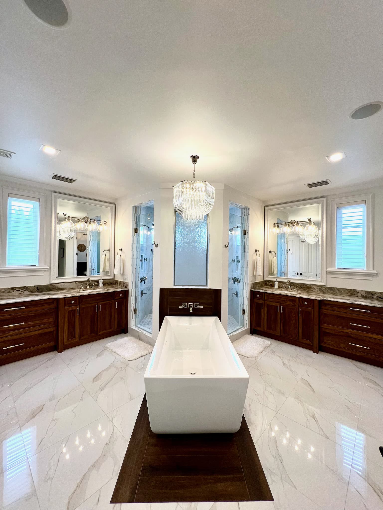Primary bath with freestanding tub and twin walnut vanities